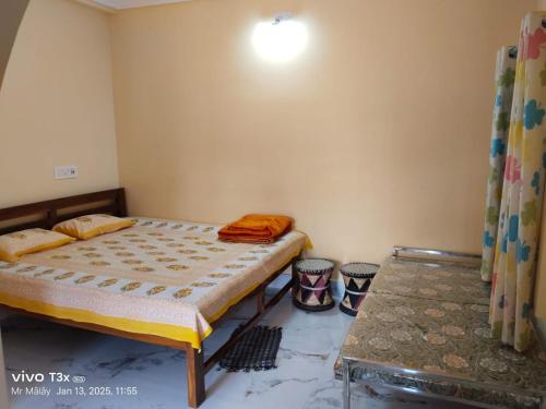 a small bedroom with a bed and a table at Megh Balika Santiniketan Family Homestay, The Best Homestay in Santiniketan in Shānti Niketan