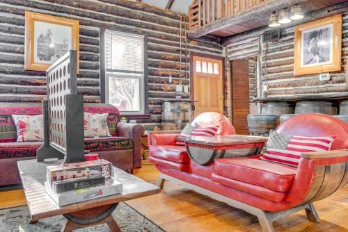 a living room with a red leather chair and a tv at The Rustic Cabin in Blakeslee