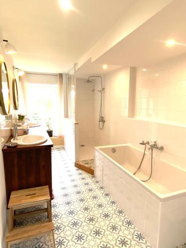 une salle de bain avec une baignoire et un lavabo dans l'établissement La Ferme familiale de Percy - 9 pers, à Percy-en-Auge