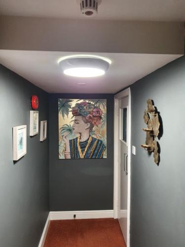a hallway with a painting of a woman on the wall at Apple Blossom Guesthouse in Rempstone