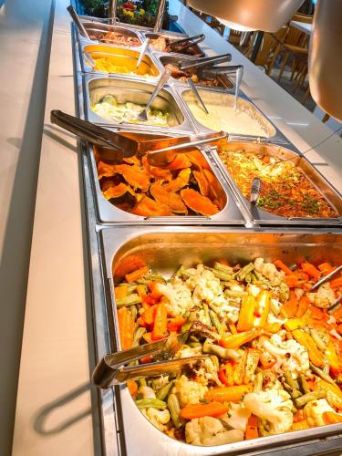a buffet line with many different types of food at Hotel Zata - Premium in Criciúma