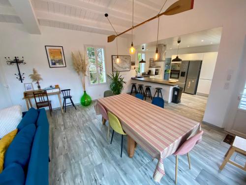 un salon avec une table et un canapé bleu dans l'établissement Maison 10 lits proximité du Port - YEU Ker Chalon, à Port-Joinville