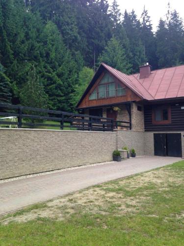 a house with a red roof and a driveway at Chata Maruska in Ružomberok