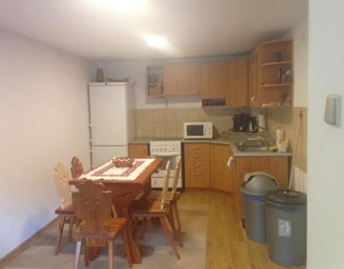 a small kitchen with a table and a refrigerator at Chata Maruska in Ružomberok