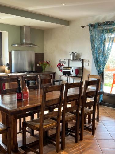 - une cuisine avec une table et des chaises en bois dans l'établissement GRAIN de SOLEIL, à Orgnac-lʼAven