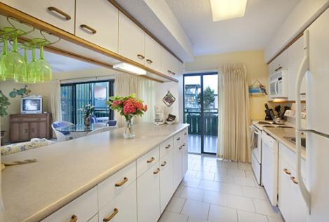 a large kitchen with a vase of flowers on a counter at Colony Cove Beach Resort in Christiansted