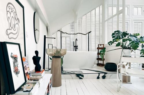 un salon avec une plante et une grande fenêtre dans l'établissement Atelier Auteuil Luxury, à Paris