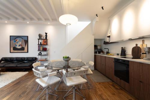 une cuisine et une salle à manger avec une table et des chaises dans l'établissement Atelier Auteuil Luxury, à Paris