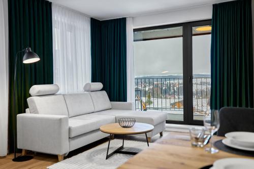 a living room with a white couch and a large window at Lagom by Mountain ways in Abertamy