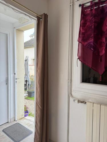 une porte menant à une chambre avec un rideau rouge dans l'établissement Vaudes chambre, à Vaudes