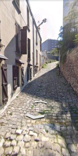 une rue pavée avec un livre sur le terrain dans l'établissement Appartement Charme petite terrasse à 400m de Paris, à Gentilly