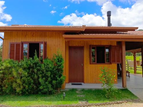 a small wooden house with a porch at Cabana Harmonia in Barracão