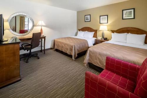 a hotel room with two beds and a red couch at Quality Inn Keystone near Mount Rushmore in Keystone
