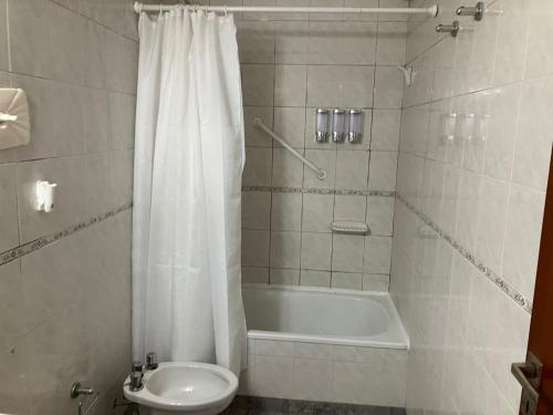 y baño con bañera, aseo y cortina de ducha. en Dpto tranquilo pleno Centro-Sur con Cochera, en Santa Fe
