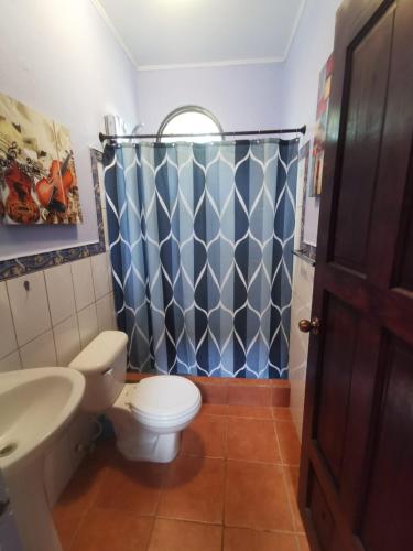 a bathroom with a toilet and a shower at Casa Sueno Colibri in Tamarindo