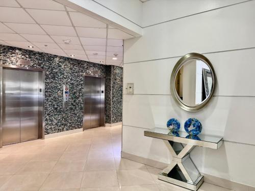 a hallway with a mirror and blue vases on a table at Spacious Apt Ocean Reserve Resort Amenities in Sunny Isles Beach