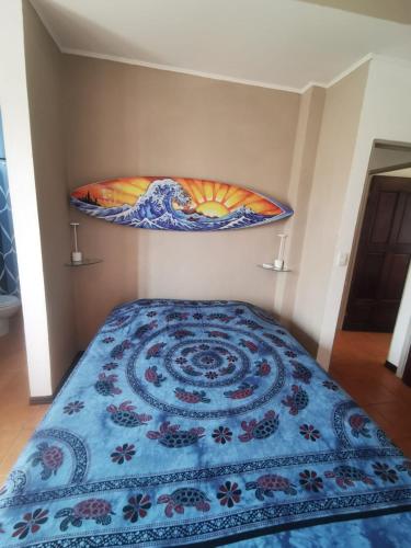 a bedroom with a bed with a blue comforter at Casa Sueno Colibri in Tamarindo