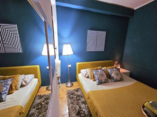 a bedroom with two beds and a blue wall at AMA Esclusive SPA Ariosto in Ferrara