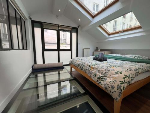 - une chambre avec un lit et un sol en verre dans l'établissement Parisian loft 120 m2 - Stylish - Paris 10th, à Paris