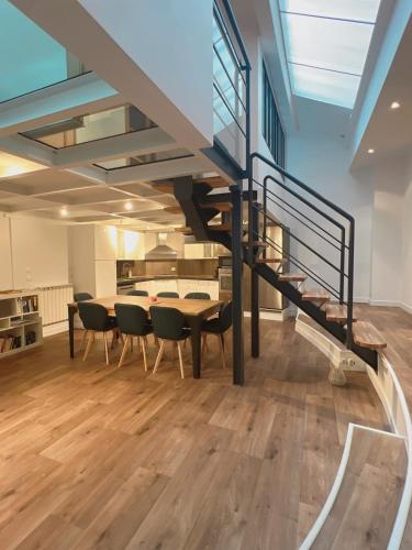 une salle à manger avec une table et des chaises et un escalier dans l'établissement Parisian loft 120 m2 - Stylish - Paris 10th, à Paris