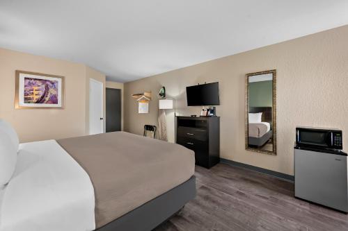 a hotel room with a bed and a television at Quality Inn Fort Myers Cape Coral in Fort Myers