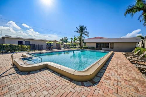 a swimming pool in a yard with chairs and a building at Quality Inn Fort Myers Cape Coral in Fort Myers