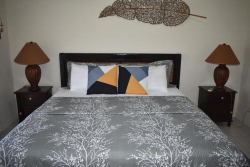 Un dormitorio con una cama con almohadas y dos lámparas. en Marina View, en Gros Islet