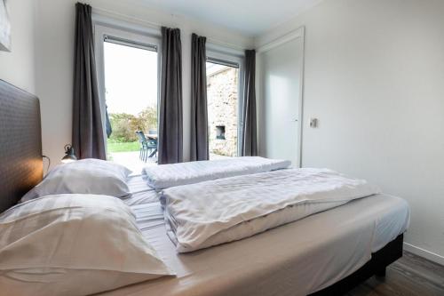 two beds in a bedroom with a window at Ravenbosch - Sauna in Valkenburg