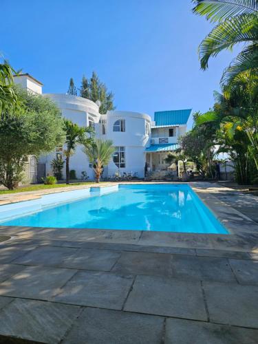 a swimming pool in front of a house at Lakaz Bigorno - Villa 200m from Blue Bay Beach in Blue Bay