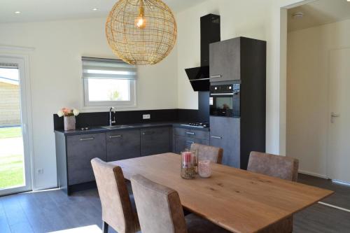 Schaelsbergerbosch- 2 Bath FireplGarde في فالكنبورخ: مطبخ مع طاولة خشبية مع كراسي ومغسلة