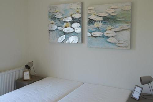 a bedroom with two paintings on the wall at Schaelsbergerbosch- 2 Bath FireplGarde in Valkenburg