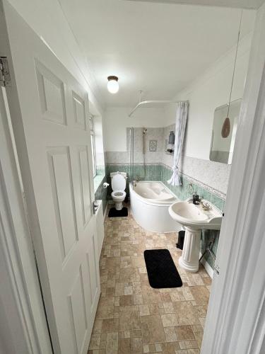 a bathroom with a tub and a toilet and a sink at Bramcote Lane Luxury Apartments in Nottingham