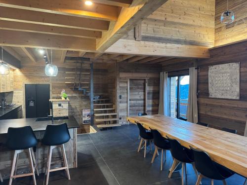 une grande salle à manger avec une grande table et des chaises en bois dans l'établissement Chalet Mélèzes, aux Angles