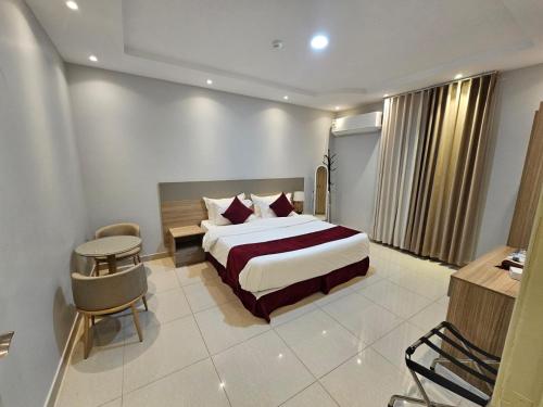 a hotel room with a bed and a desk and chair at نجمة راحتي للشقق المخدومة العزيزية in Riyadh