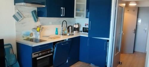 - une cuisine bleue avec un évier et des armoires bleues dans l'établissement SIX-FOURS vue mer et situé devant la plage, à Six-Fours-les-Plages