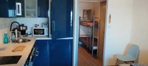 - une cuisine bleue avec évier et four micro-ondes dans l'établissement SIX-FOURS vue mer et situé devant la plage, à Six-Fours-les-Plages