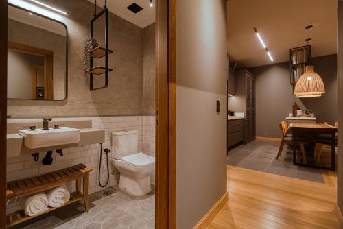 a bathroom with a toilet and a sink at Mater Hotel in Canela