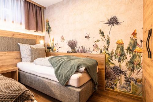 a bedroom with a bed with a floral wallpaper at Pension Kumbichlhof in Mayrhofen