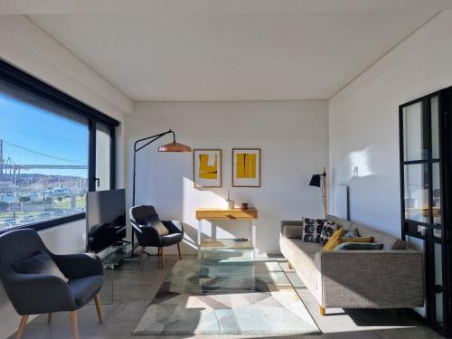 a living room with a couch and a desk at MBird Riverside 2BD Flat with garage in Lisbon