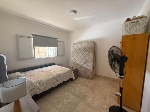 a bedroom with a bed and a fan in it at Casa en Tanti con pileta in Tanti