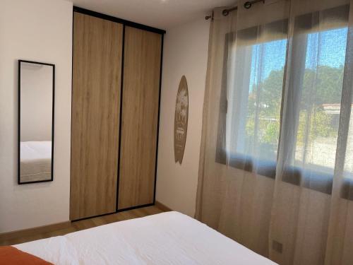 - une chambre avec une armoire en bois et une fenêtre dans l'établissement Sole e Mare, à Mimizan-Plage