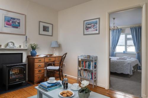 ein Wohnzimmer mit einem Kamin und ein Schlafzimmer in der Unterkunft The Boathouse for two, St Davids, Garage Parking in St. Davids