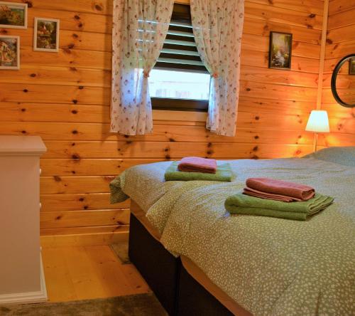 a bedroom with a bed with two towels on it at The Village Cottage in Natsovtsi
