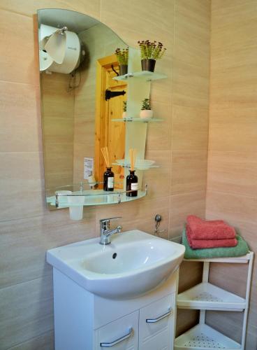 a bathroom with a sink and a mirror at The Village Cottage in Natsovtsi