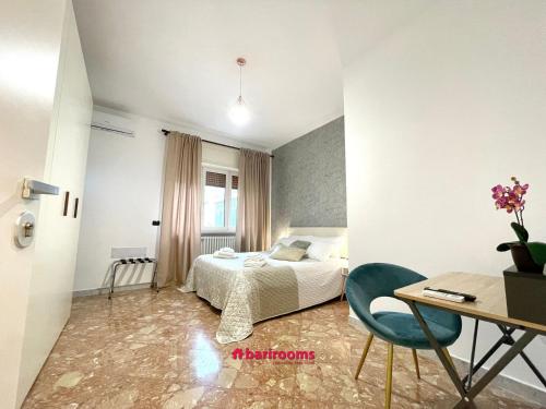 a bedroom with a bed and a desk and a table with a chair at Barirooms Piccinni in Bari