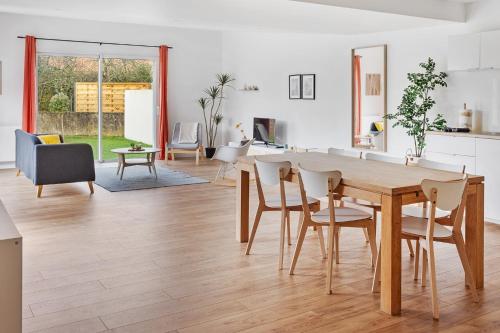 Il dispose d'une cuisine et d'un salon avec une table et des chaises en bois. dans l'établissement La Catinou - Maison confortable et spacieuse, à Saint-Sébastien-sur-Loire
