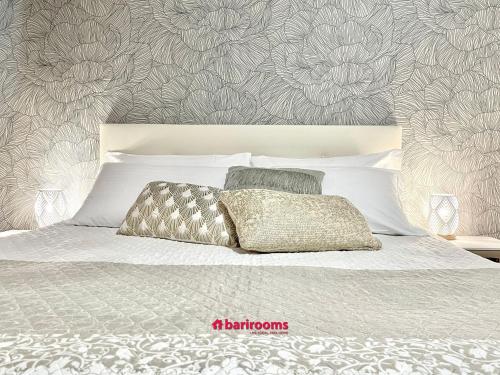 a bedroom with a white bed with a floral wallpaper at Barirooms Piccinni in Bari