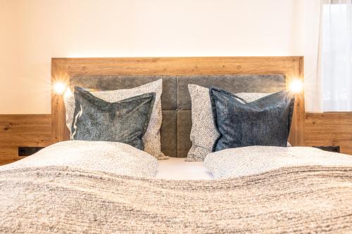 a bedroom with a bed with two pillows at Pension Kumbichlhof in Mayrhofen