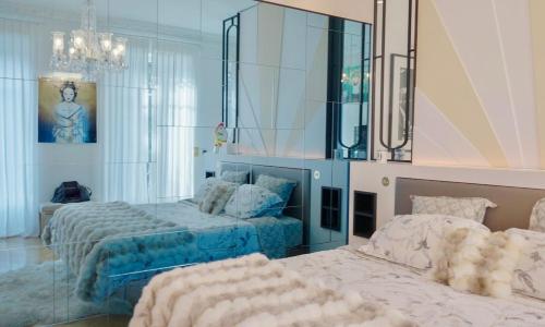 une chambre avec deux lits et un miroir dans l'établissement Le Prestige Haussmannien, à Toulouse