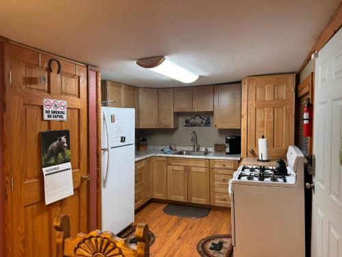 a kitchen with wooden cabinets and a white refrigerator at Gonzales Cozy Little Bear Cabin in Ruidoso